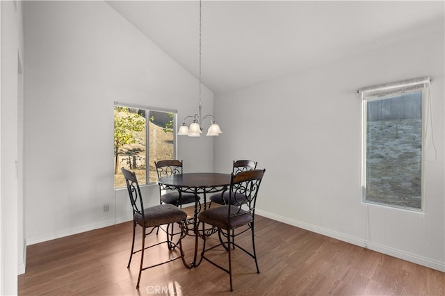 dining area with dark hardwood / wood-style floors, a chandelier, and high vaulted ceiling