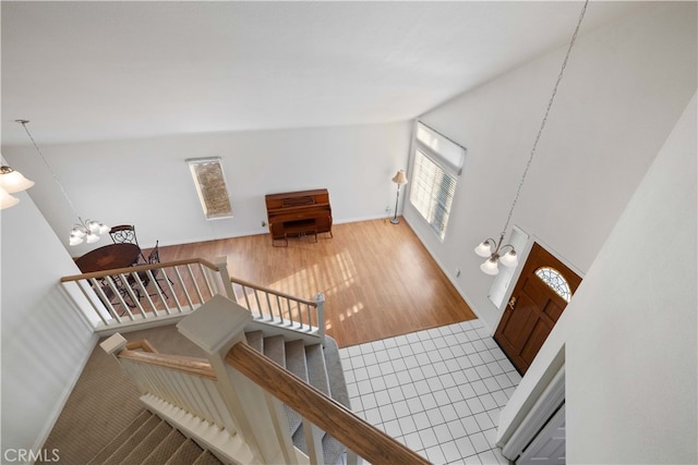 interior space with wood-type flooring, a high ceiling, and a notable chandelier