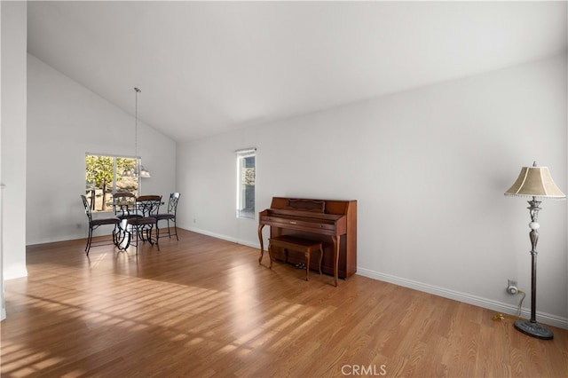 interior space with high vaulted ceiling, light hardwood / wood-style floors, and an inviting chandelier