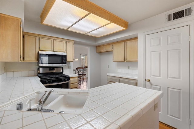 kitchen featuring stainless steel appliances and tile counters