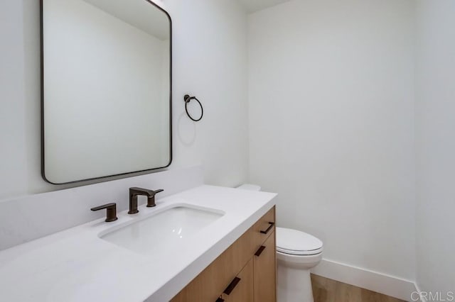 bathroom with vanity, hardwood / wood-style floors, and toilet