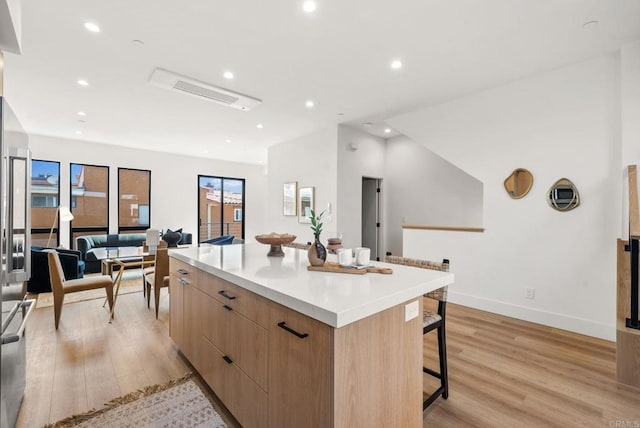 kitchen with a breakfast bar area, a large island, and light wood-type flooring