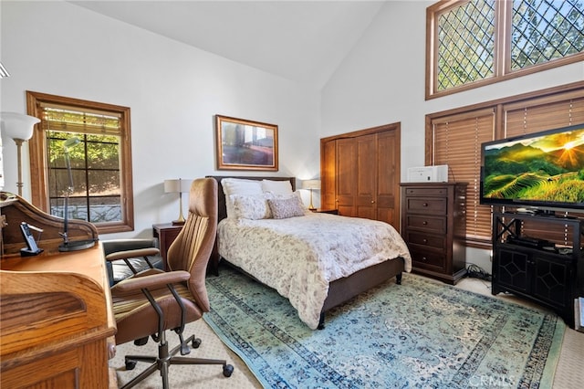 carpeted bedroom with high vaulted ceiling