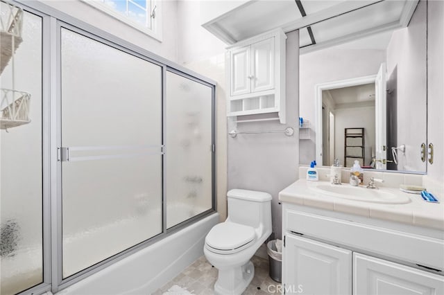 full bathroom featuring toilet, vanity, and bath / shower combo with glass door