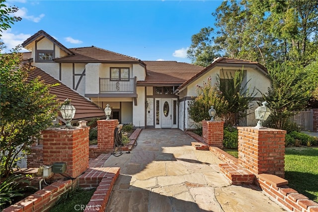 view of front of property featuring a balcony and a patio area