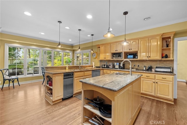 kitchen with appliances with stainless steel finishes, hanging light fixtures, a kitchen island with sink, and light brown cabinets