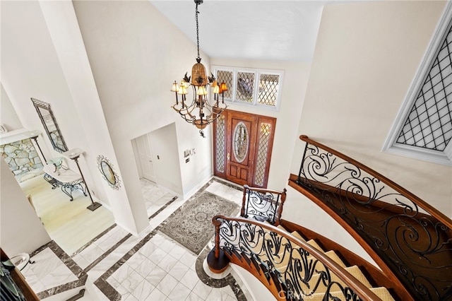 foyer featuring an inviting chandelier and a towering ceiling