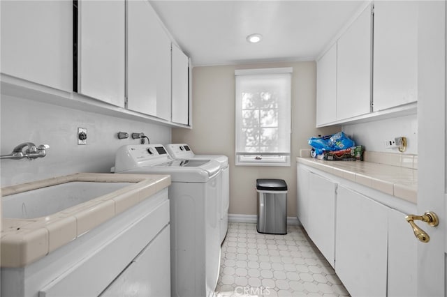 laundry area featuring washer and clothes dryer, sink, and cabinets