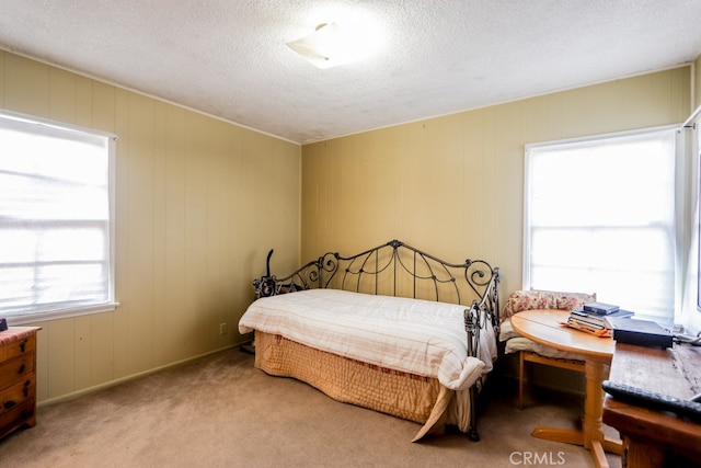 carpeted bedroom with multiple windows and a textured ceiling