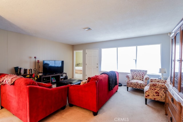 living room with light colored carpet, a textured ceiling, and wooden walls