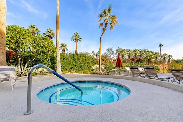 view of swimming pool featuring a patio and a hot tub