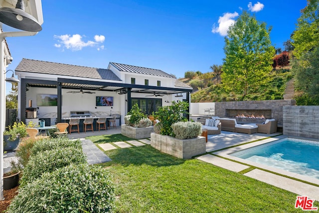 back of house featuring a pergola, a patio area, a bar, an outdoor hangout area, and an outdoor kitchen