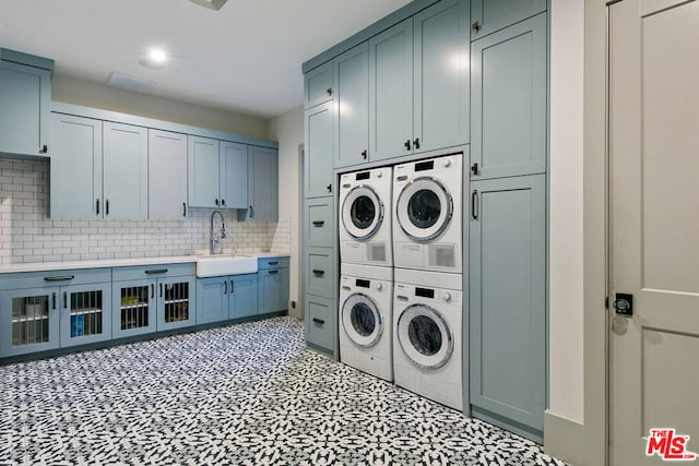 laundry room with cabinets, stacked washer / drying machine, sink, and washing machine and dryer