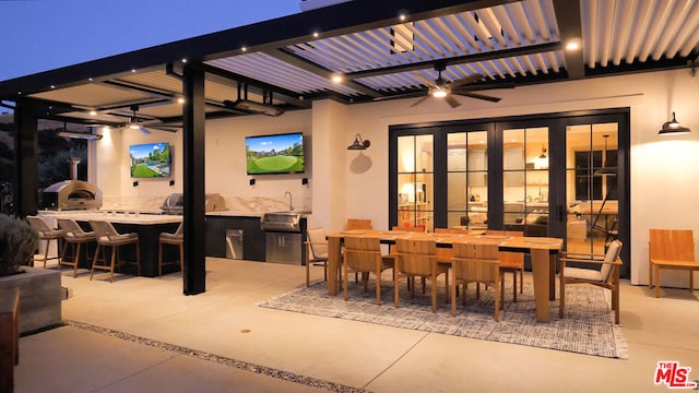 view of patio with area for grilling, ceiling fan, and a bar