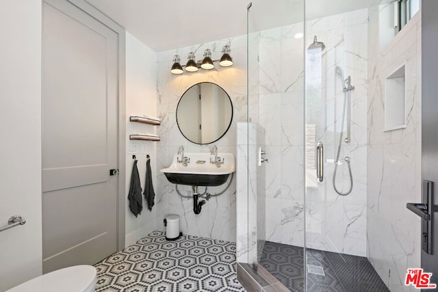 bathroom featuring toilet, a shower with shower door, and sink