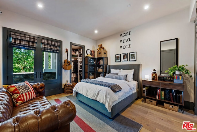 bedroom with french doors and light hardwood / wood-style flooring