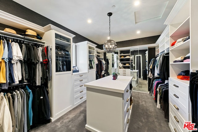 walk in closet with dark carpet