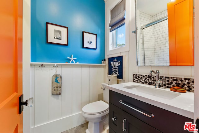 bathroom with walk in shower, toilet, vanity, hardwood / wood-style floors, and backsplash