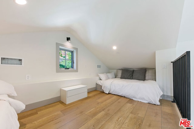 bedroom with vaulted ceiling and light hardwood / wood-style flooring