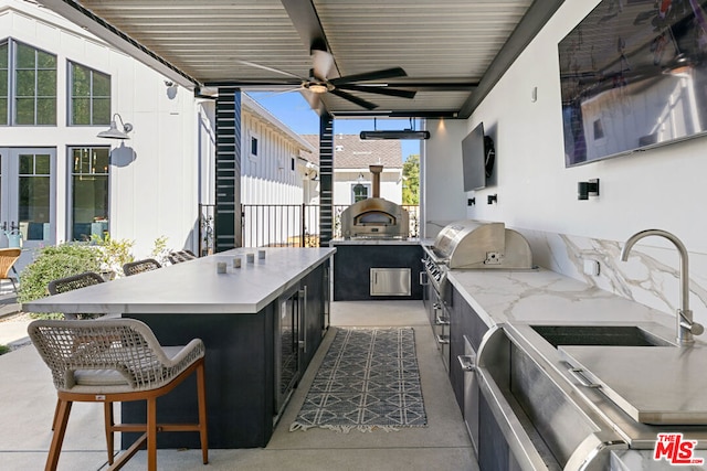 view of patio / terrace featuring area for grilling, grilling area, an outdoor bar, and ceiling fan