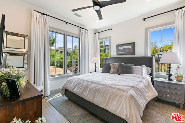 bedroom with multiple windows, light wood-type flooring, and ceiling fan