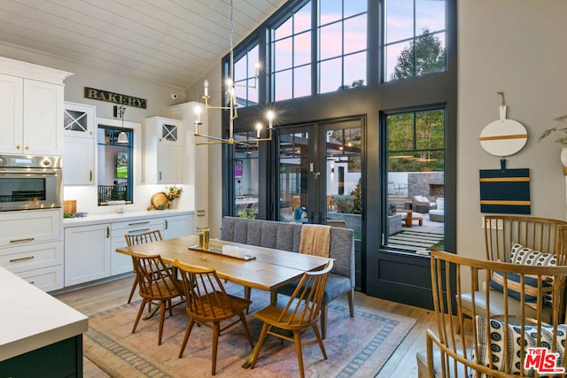 dining area featuring an inviting chandelier, light hardwood / wood-style flooring, high vaulted ceiling, and wooden ceiling