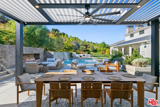 view of patio / terrace with an outdoor living space with a fireplace, pool water feature, and ceiling fan