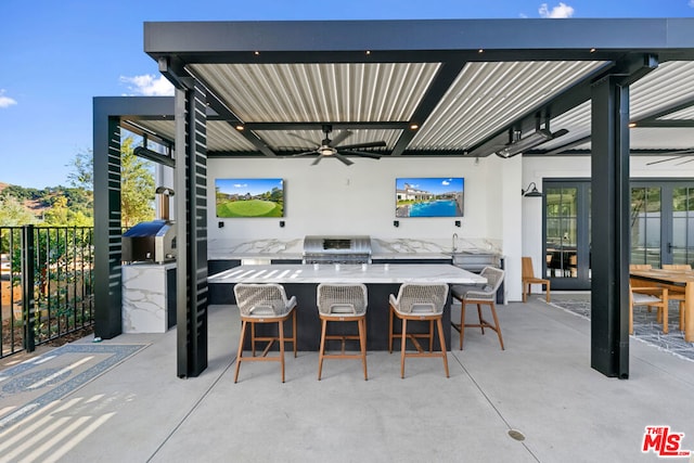 view of patio / terrace with ceiling fan, grilling area, exterior bar, and exterior kitchen