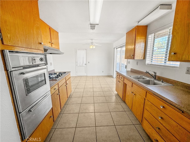 kitchen featuring appliances with stainless steel finishes, sink, light tile patterned floors, and ceiling fan