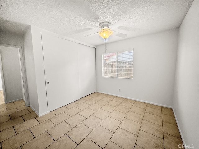 tiled spare room with ceiling fan and a textured ceiling