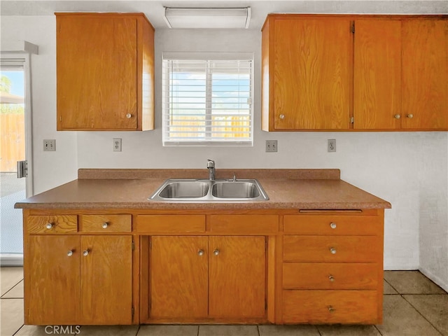 kitchen featuring light tile patterned floors and sink