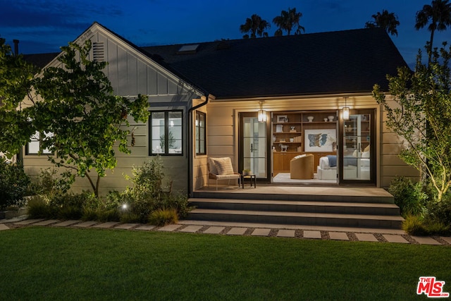 rear view of property with a lawn