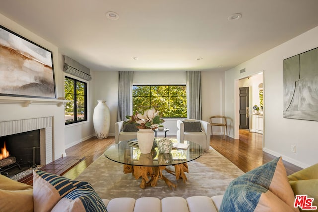 living room featuring hardwood / wood-style flooring and a brick fireplace