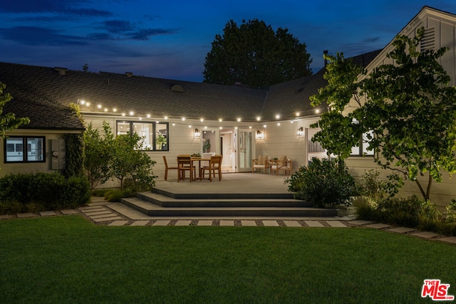 back house at dusk with a yard