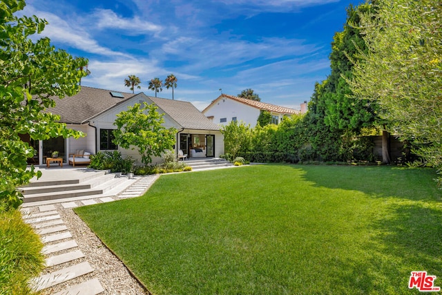 rear view of property featuring a lawn