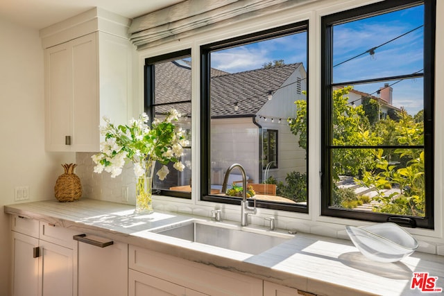 kitchen with white cabinetry, sink, and plenty of natural light