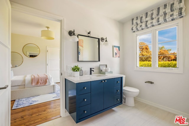 bathroom with hardwood / wood-style floors, vanity, and toilet