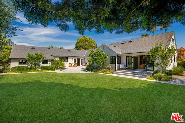 back of house with a patio area and a yard