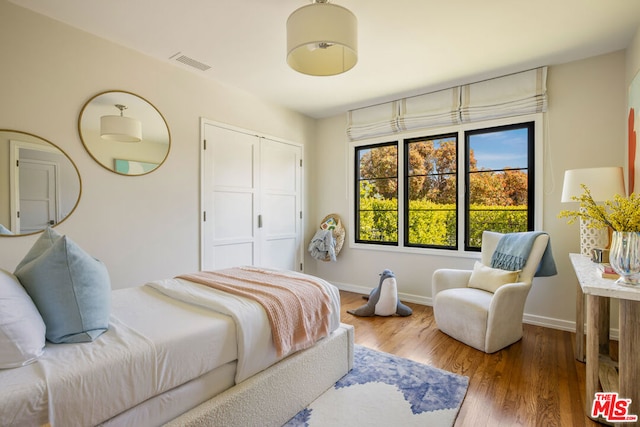 bedroom featuring hardwood / wood-style floors and a closet