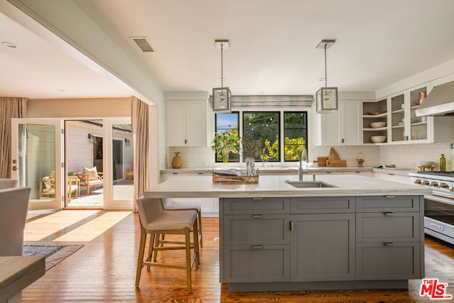 kitchen with white cabinets, light hardwood / wood-style floors, tasteful backsplash, and gray cabinetry