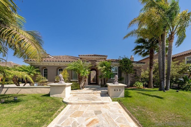 mediterranean / spanish-style house featuring a front yard