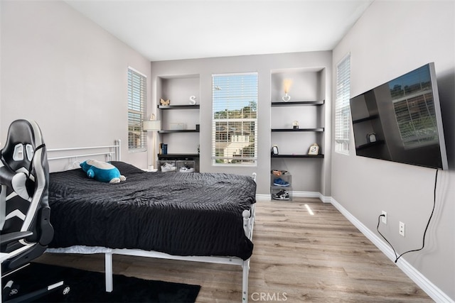 bedroom with light wood-type flooring and multiple windows