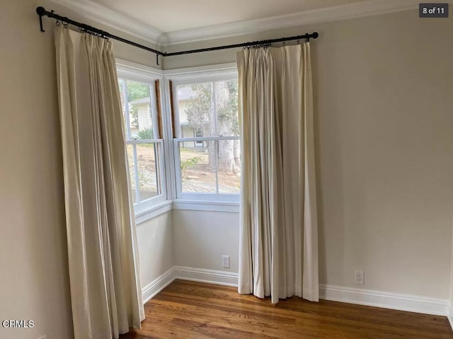 unfurnished room with wood-type flooring and ornamental molding