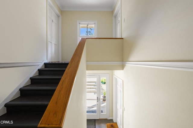 stairway featuring crown molding and a wealth of natural light