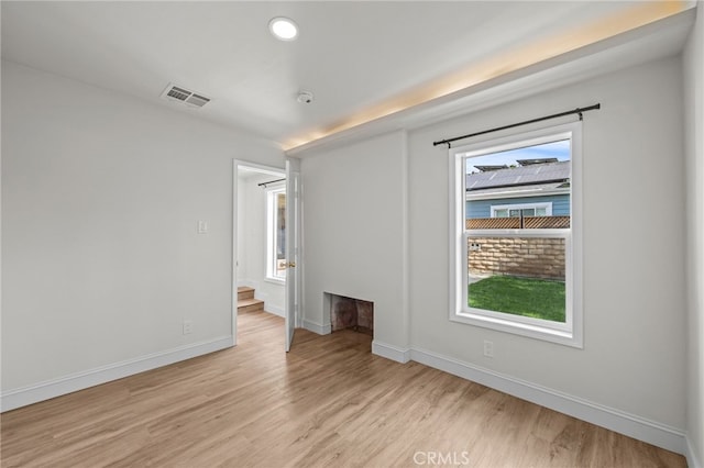 unfurnished room featuring light wood-type flooring and a healthy amount of sunlight