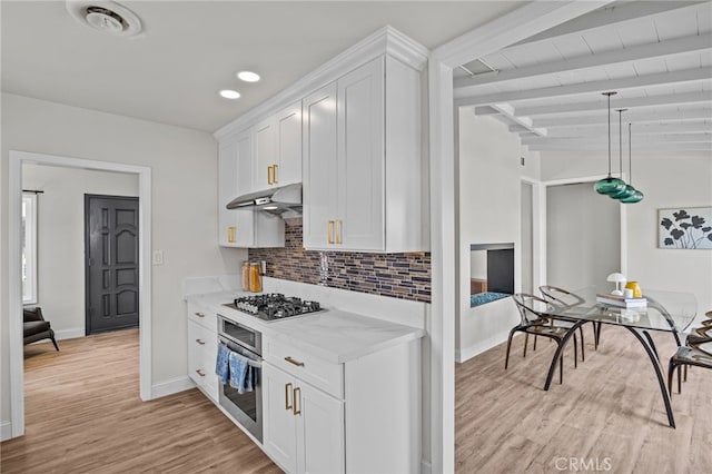 kitchen with light stone counters, white cabinets, beam ceiling, stainless steel appliances, and light wood-type flooring