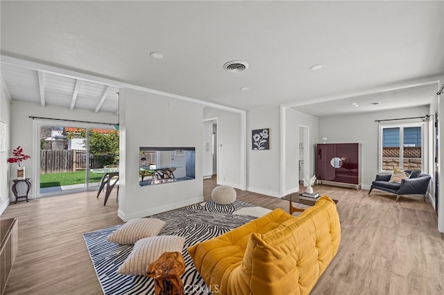 living room with light hardwood / wood-style floors and beamed ceiling