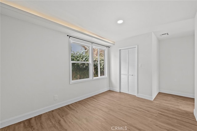 unfurnished bedroom with light hardwood / wood-style flooring and a closet