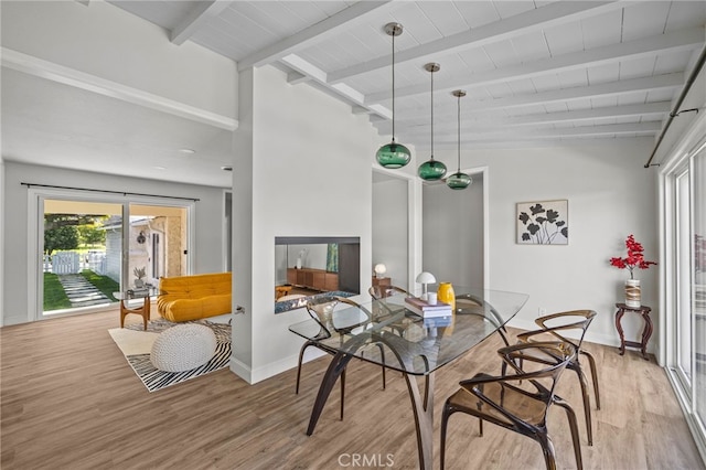 dining space featuring light hardwood / wood-style flooring, vaulted ceiling with beams, and wooden ceiling