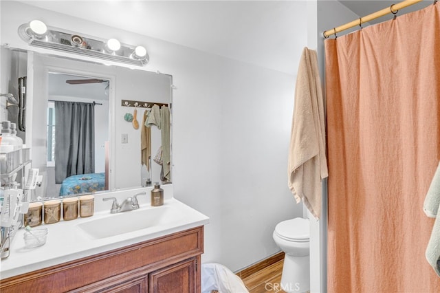 bathroom with hardwood / wood-style floors, vanity, and toilet